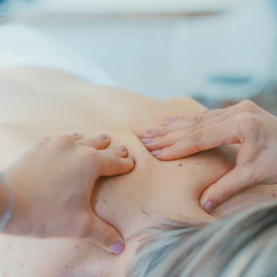 person massaging the back of a woman